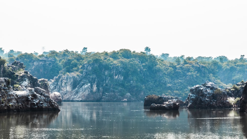 a body of water with a rocky hill in the background