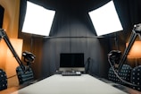 a desk with a laptop and microphones