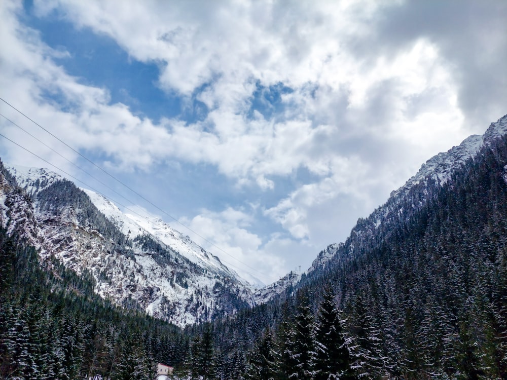 a mountain with trees and clouds