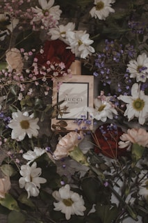 A vibrant bouquet of fresh flowers next to a boldbloom fragrance bottle, symbolizing purity and passion.