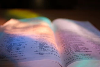 An open motivational book with sunlight shining on its pages.