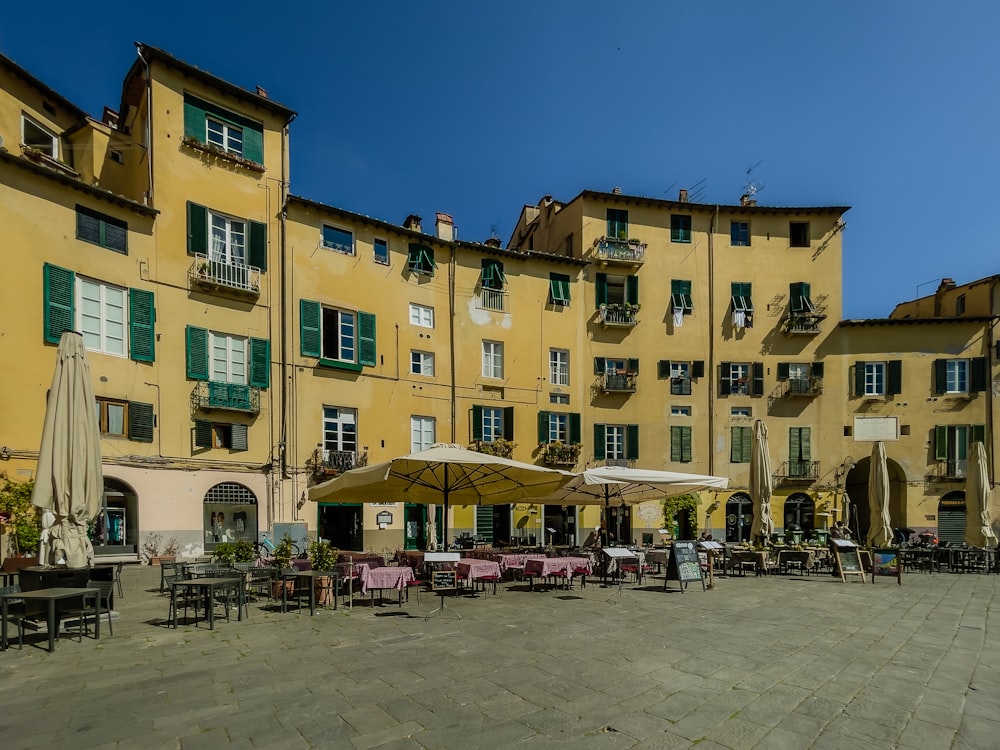 a group of tables and chairs outside of a building