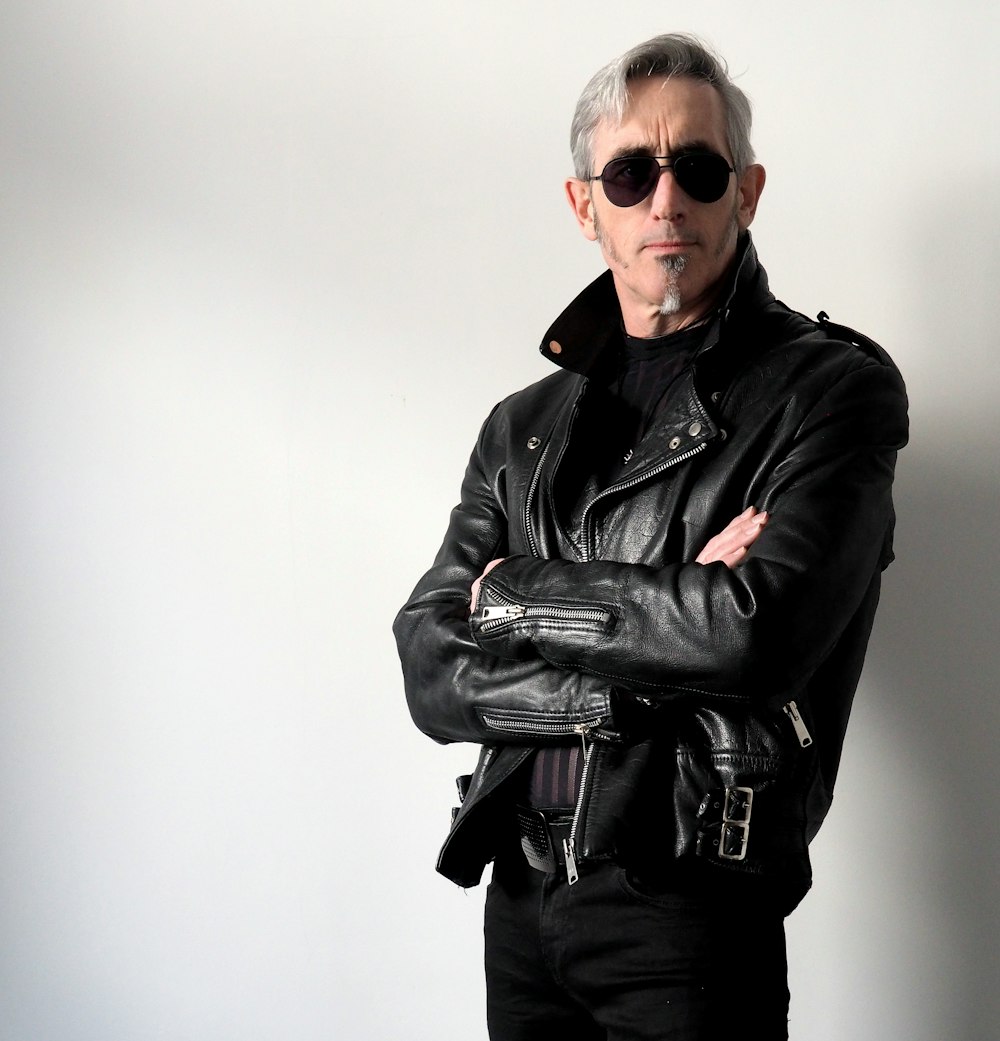 a person wearing a leather jacket and sunglasses