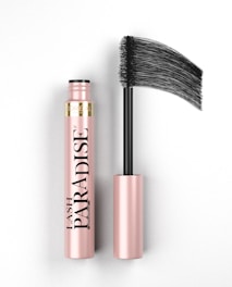 A pink and black mascara tube is displayed with its brush applicator extended, showcasing the brand name 'Lash Paradise' prominently on the tube. The overall look is sleek and elegant with a focus on the product's design.
