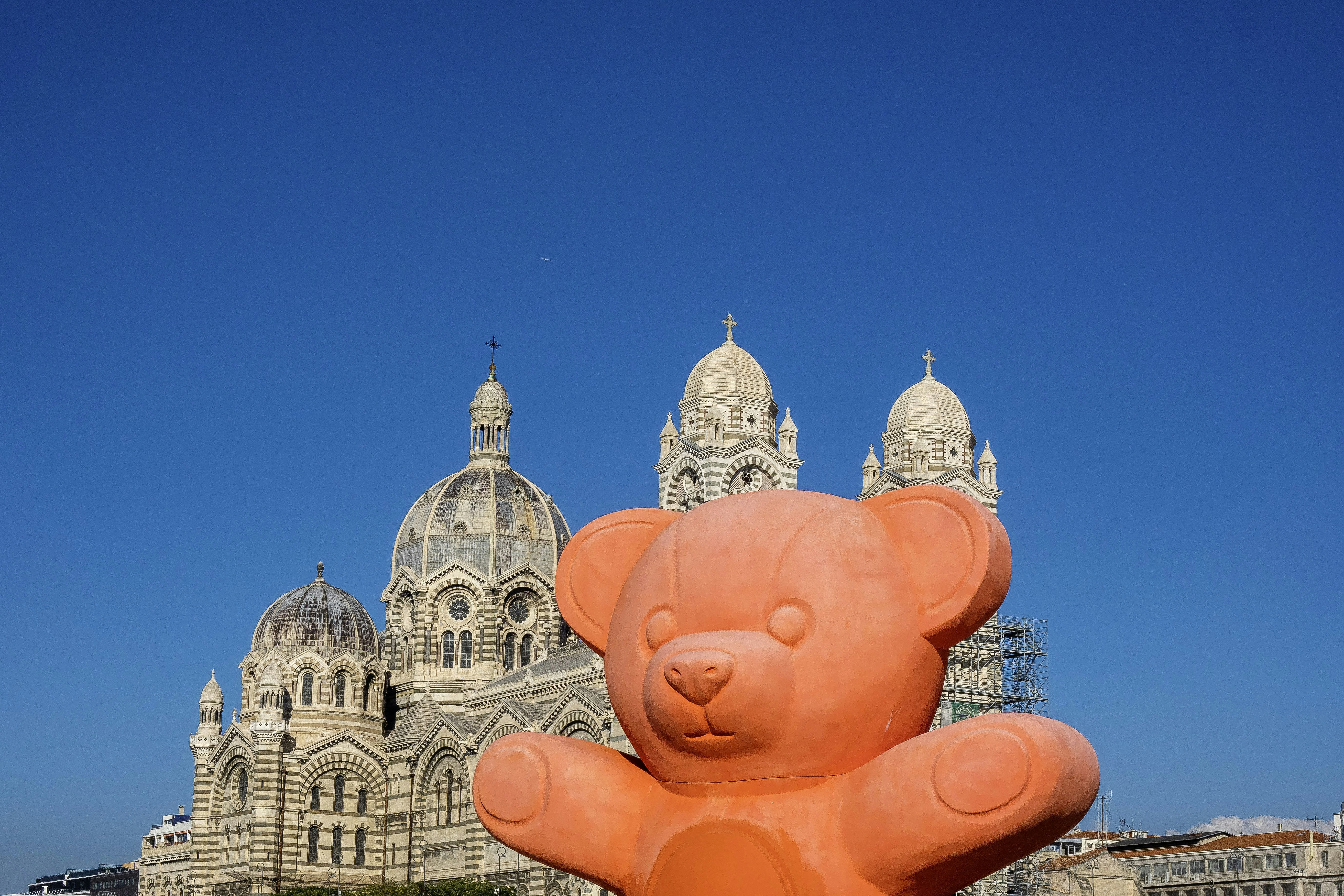 orange bear in front of a church in marseille, france