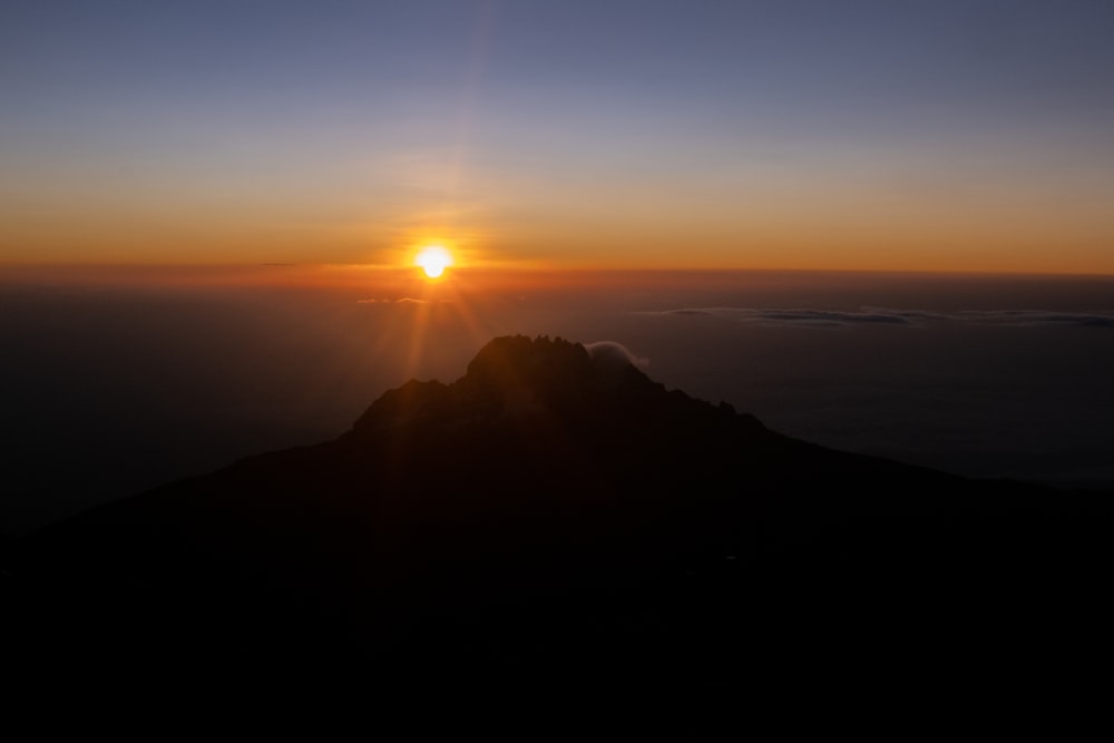 a sunset over a mountain