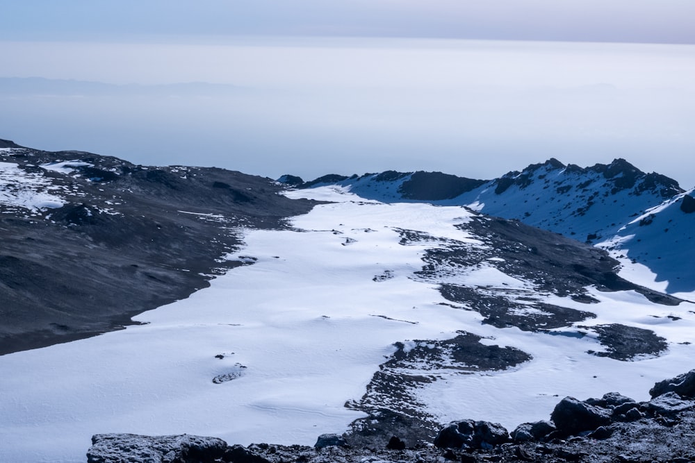 a snowy landscape with water and mountains