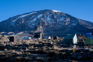 A cozy mountain camp with tents and a small store under the Patagonian sky.