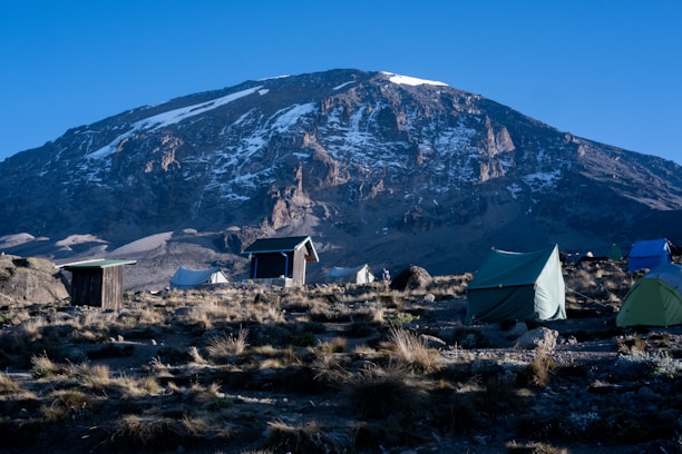 A cozy mountain camp with tents and a small store under the Patagonian sky.