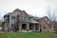 Exterior view of a newly constructed family home with stone accents and a welcoming porch.