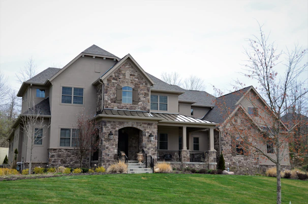 Front exterior view of a modern house with large windows and a welcoming porch.