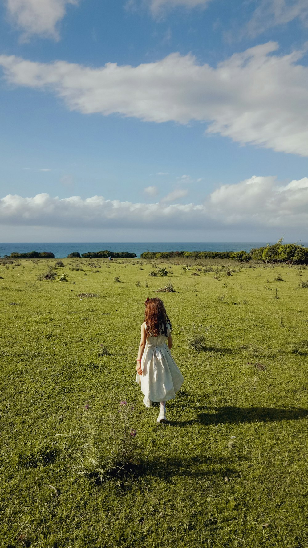 Una persona con un vestido blanco caminando en un campo