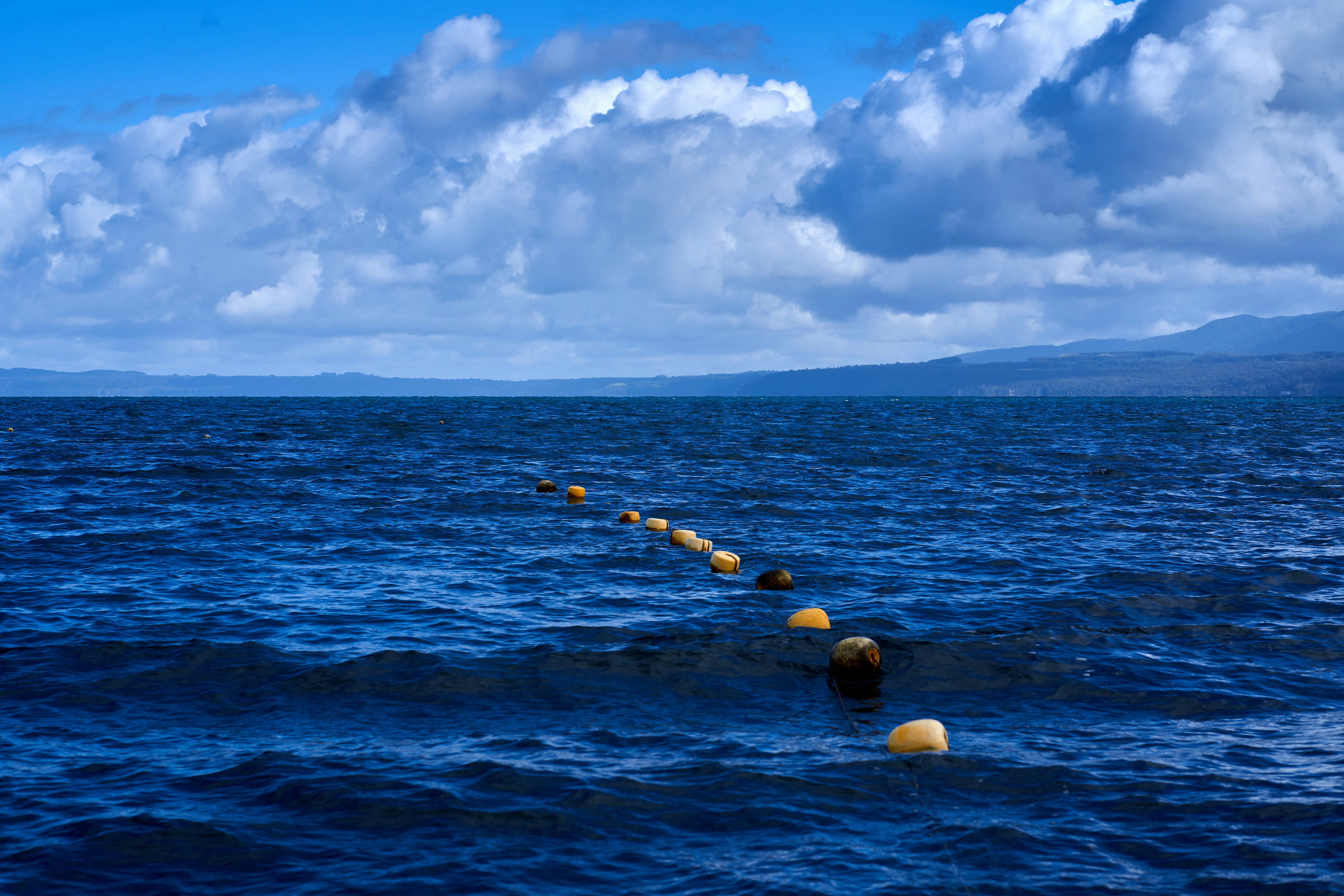 a body of water with rocks in it and a cloudy sky above