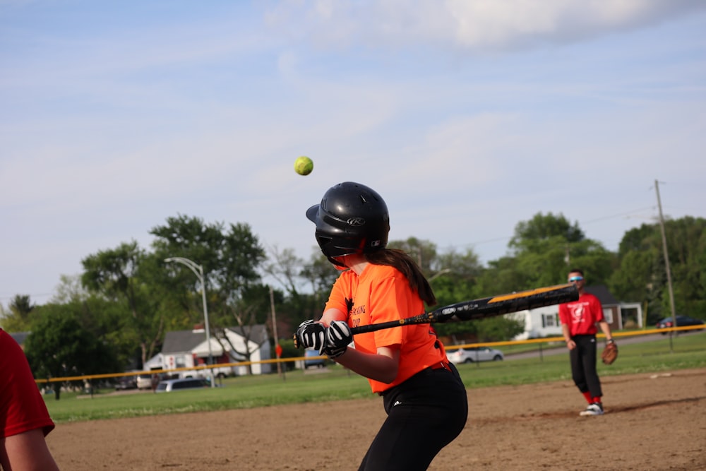 Una niña balanceando un bate de béisbol