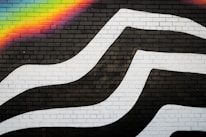 Colorful mural representing the LGBTQIA+ community inspired by Juan's designs.