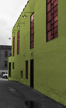 Wide shot of a commercial building exterior with subtle electric lime green lighting highlights.