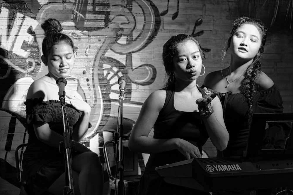 a group of women sitting on a stage with microphones