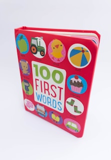 A children's board book with a bright red cover featuring the title '100 First Words' in large colorful letters. Surrounding the title are various circular illustrations including an apple, tractor, chick, ball, cupcake, socks, bus, and car, each labeled with their corresponding word.