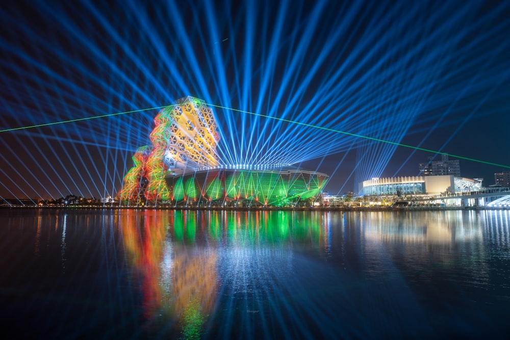 a body of water with a building and lights in the background