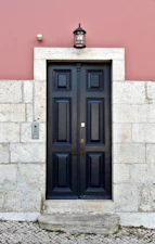 a black door on a stone building
