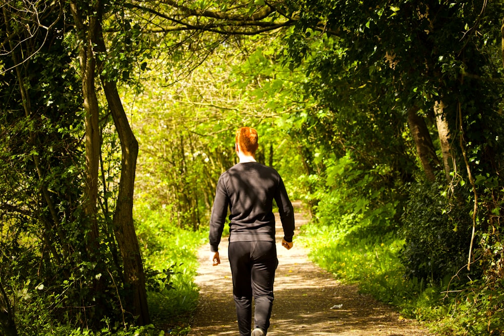 a man walking on a path in the woods