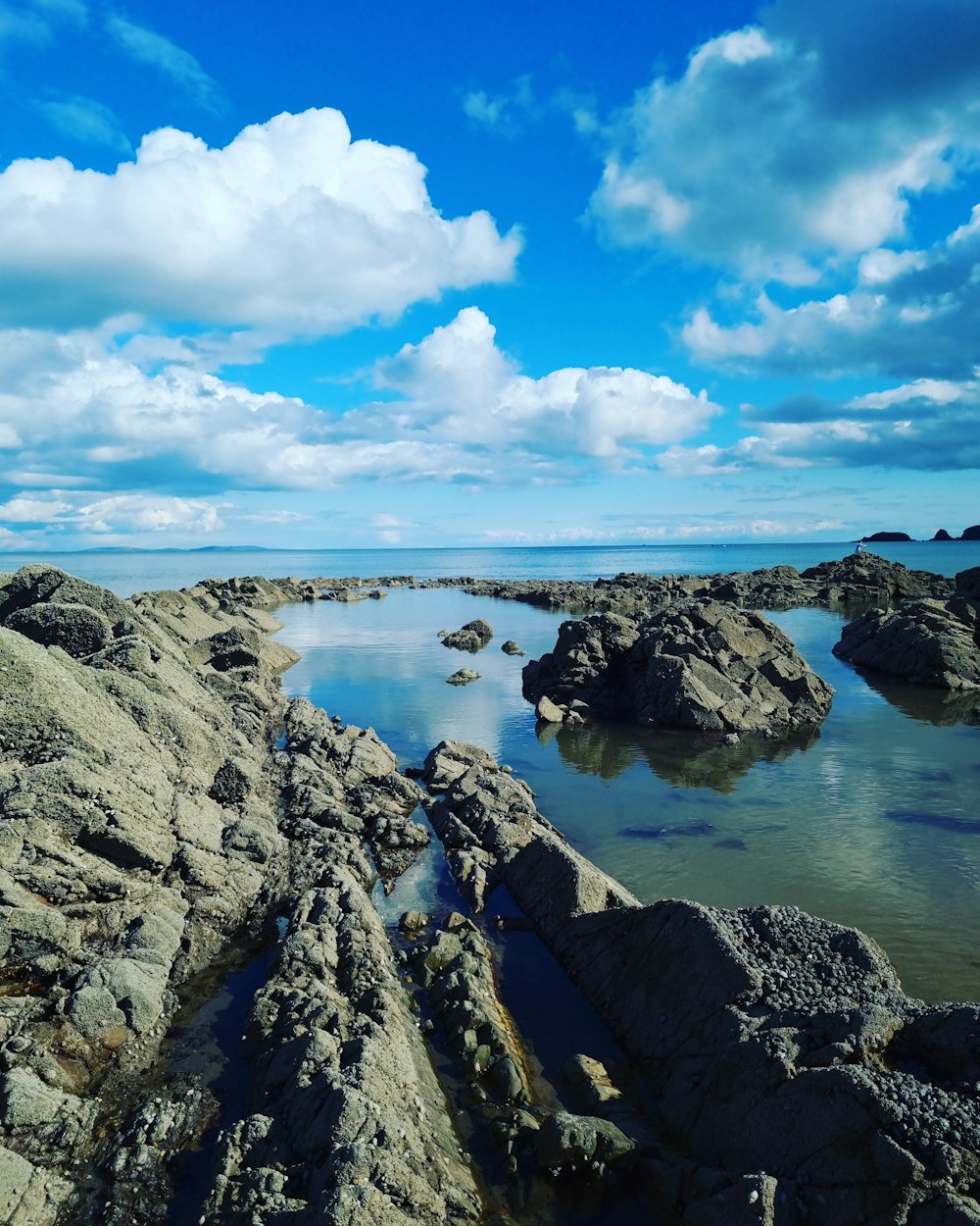 uma praia rochosa com água azul