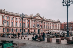 a large building with many windows with Capitole de Toulouse in the background