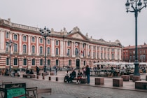 a large building with many windows with Capitole de Toulouse in the background