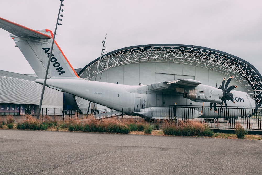 a plane is parked outside of a hangar