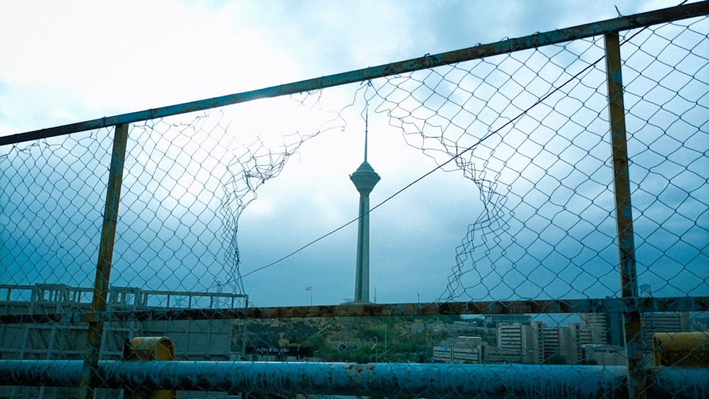 a fence with a tower in the background