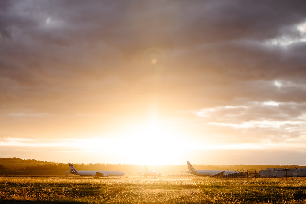 a couple of airplanes sit in a field