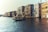 A scenic view of a gondola gliding through a canal in Venice, with grand historical buildings lining the water. The architecture features classic Venetian style with ornate windows and balconies. The water reflects the warm sunlight, creating a peaceful ambiance.