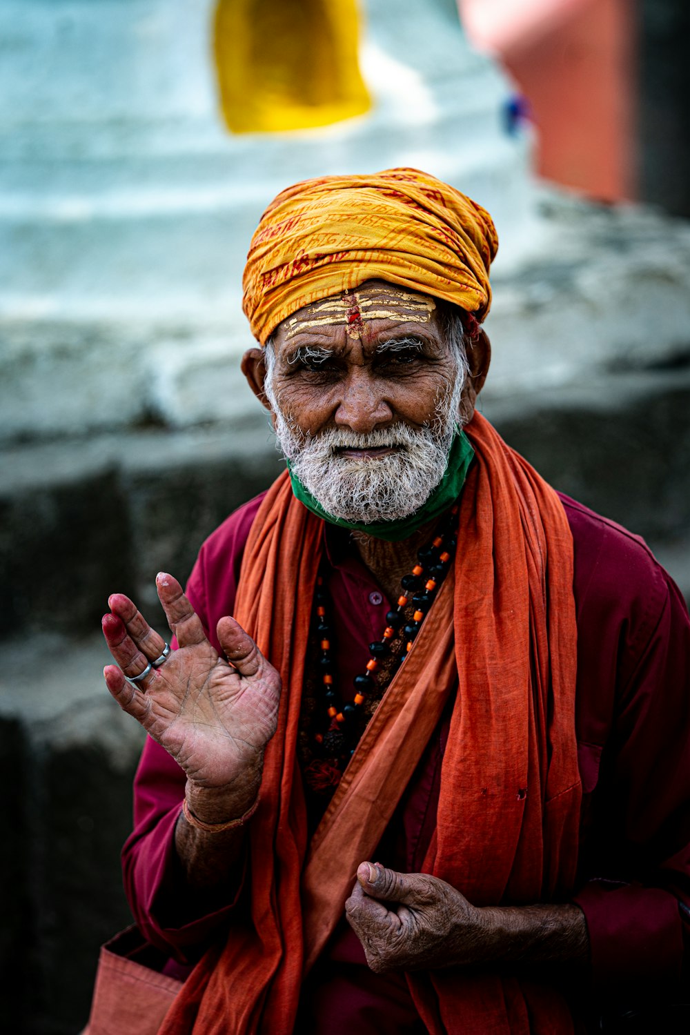 a man wearing a red robe and a yellow headdress