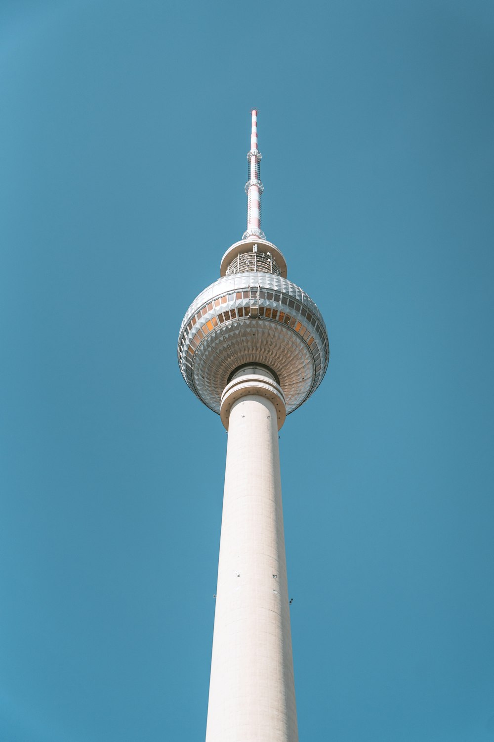 a tall tower with a circular top with Fernsehturm Berlin in the background