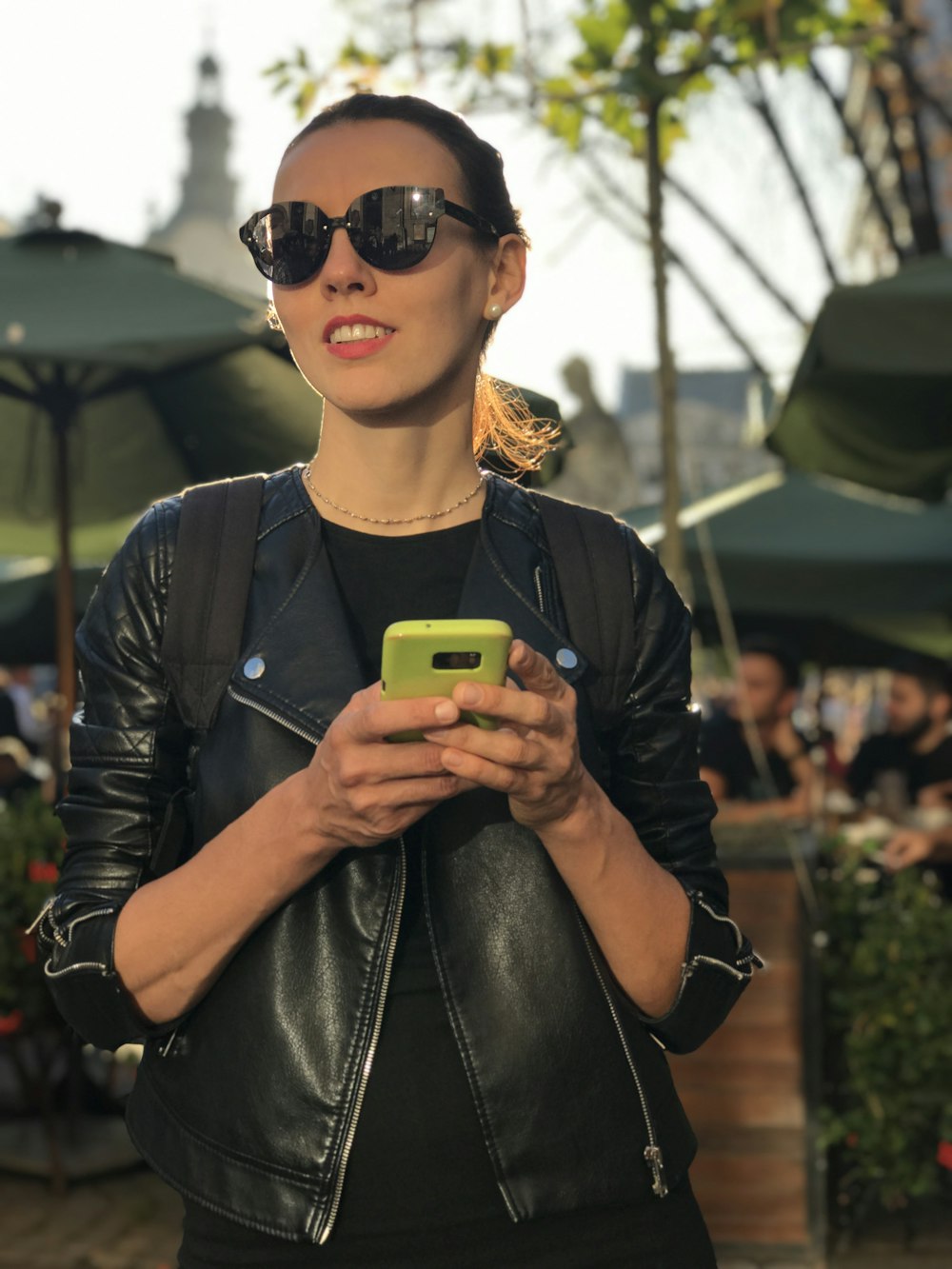 a person wearing sunglasses and holding a phone