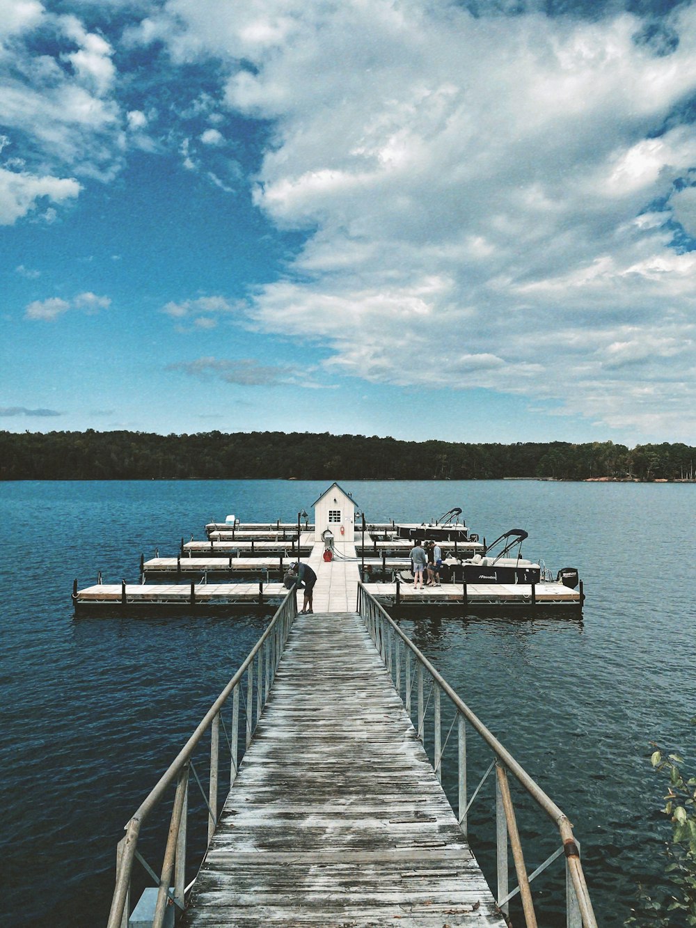 a dock leading to a small house on a lake