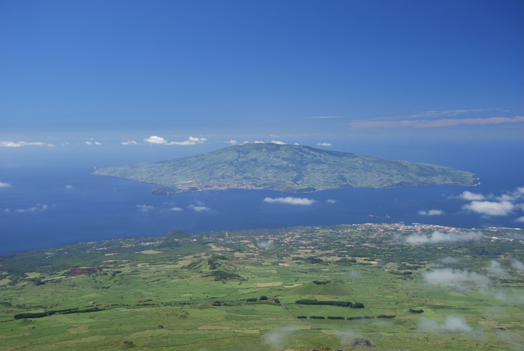 a large green landscape with a mountain in the distance, The Faial Island seen from the slopes of the Pico mountain.<p></figure>Azores Islands, Portugal.
