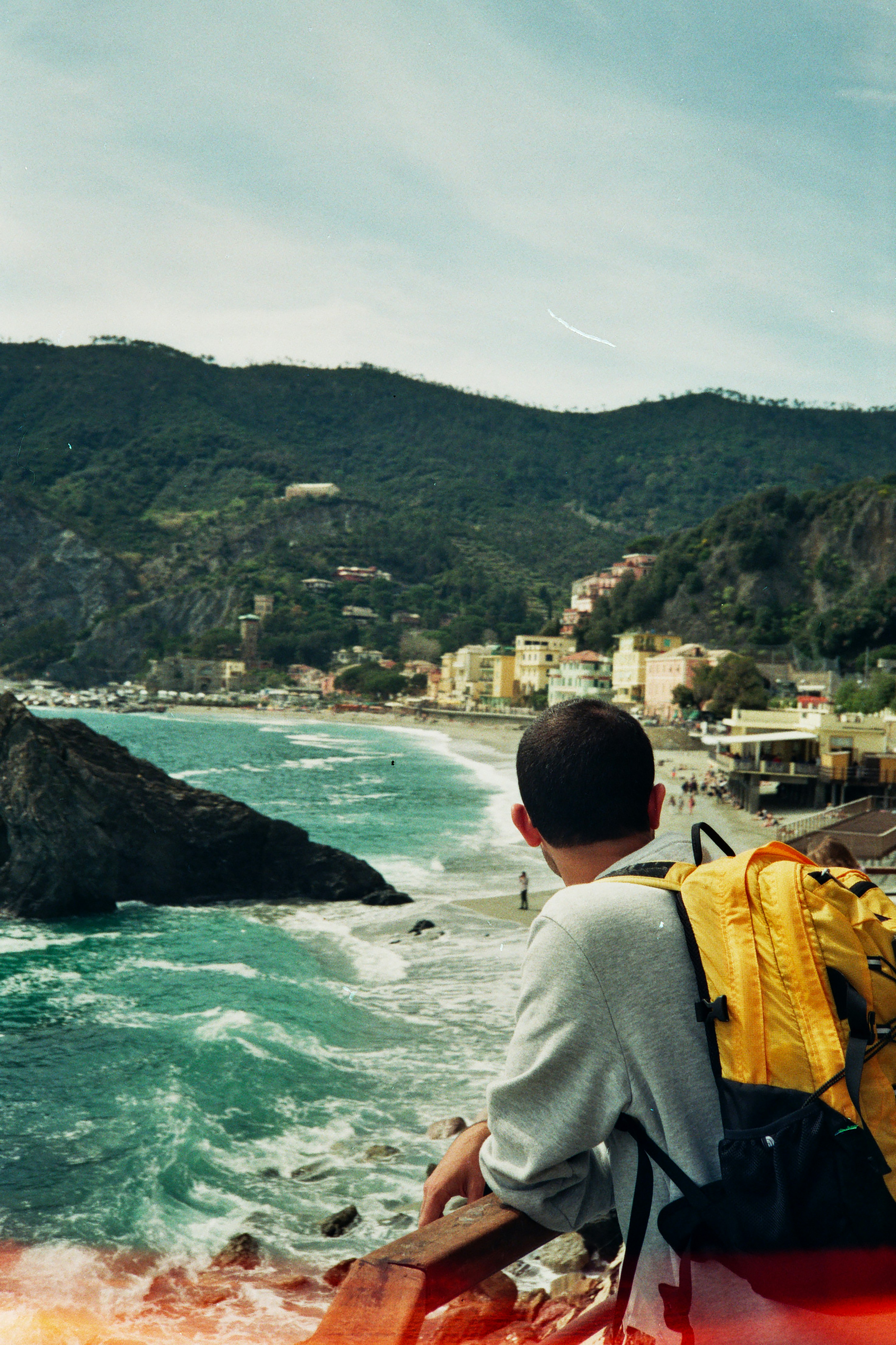 a man sitting on a boat looking at a town on the water