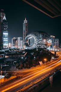 a city with a large globe and buildings at night