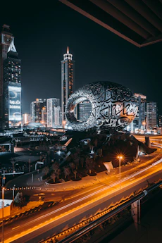 a city with a large globe and buildings at night