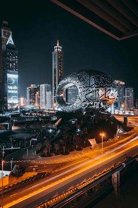 a city with a large globe and buildings at night