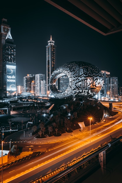 a city with a large globe and buildings at night