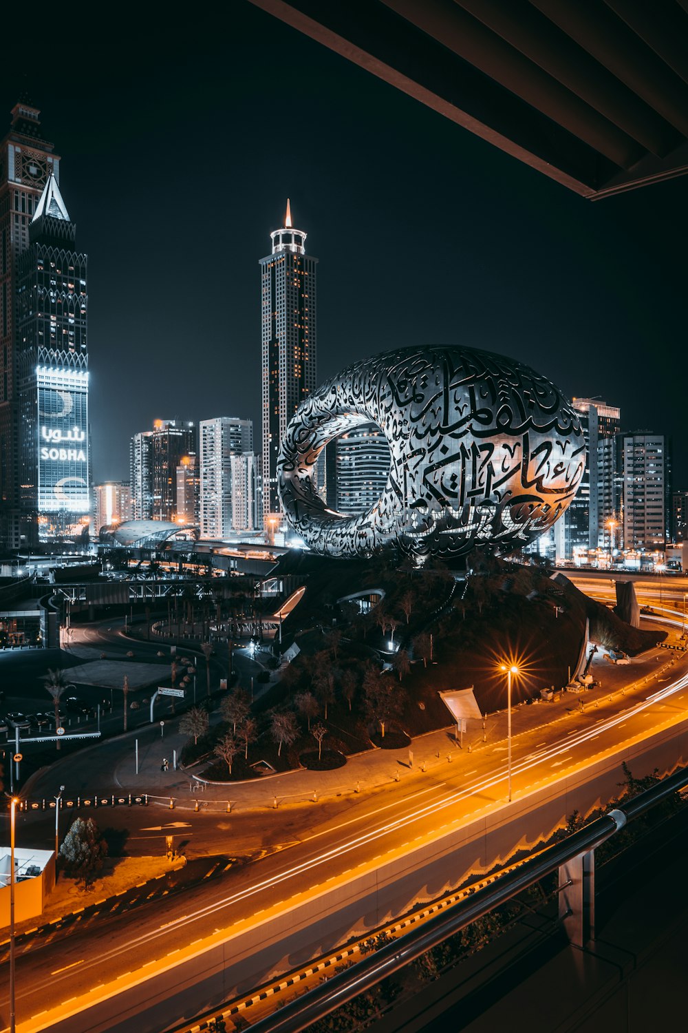 a city with a large globe and buildings at night