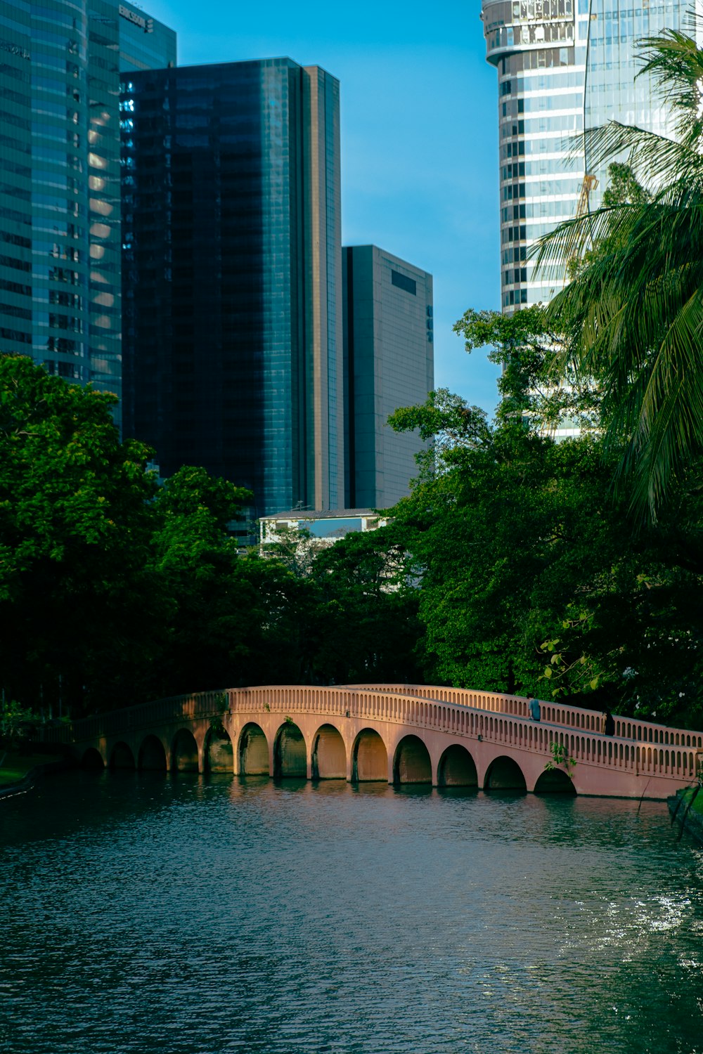 a bridge over a river with tall buildings in the background