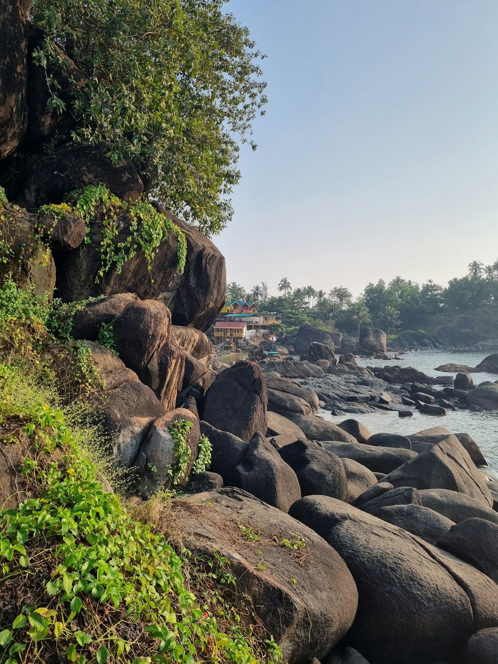 a rocky beach with a house in the distance