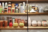 a shelf is filled with vases