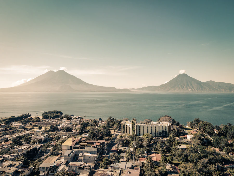 Vista aérea del casco urbano de Panajachel a la orilla del lago, con los volcanes al fondo