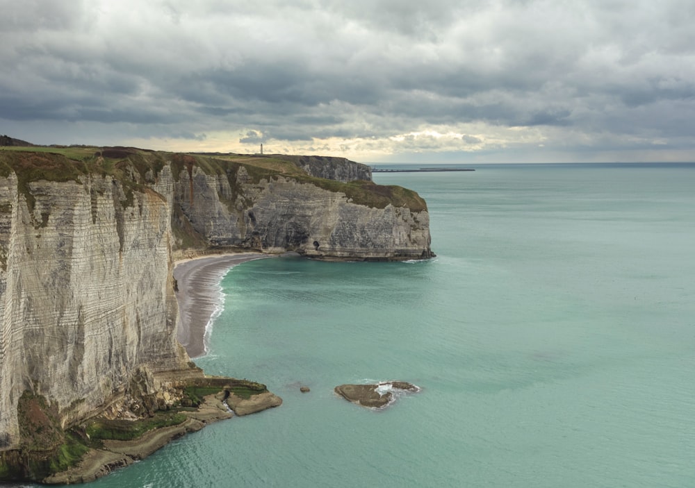 Eine Klippe mit Strand und Wasser darunter