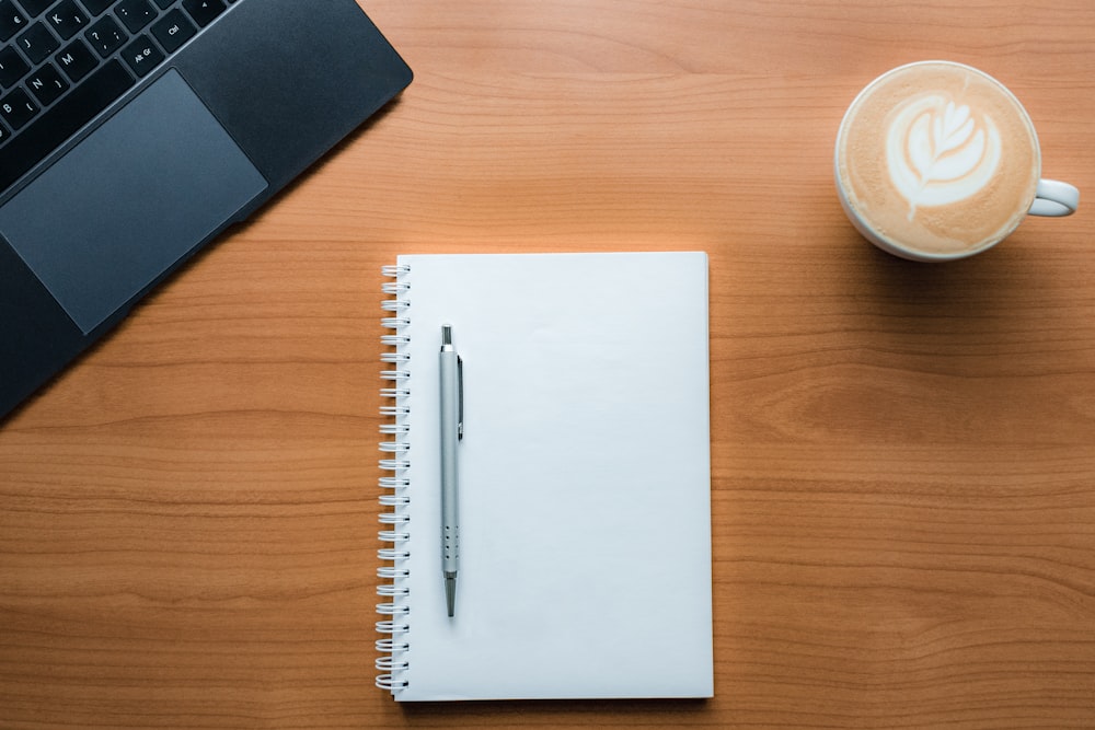 a pen and a cup of coffee on a table