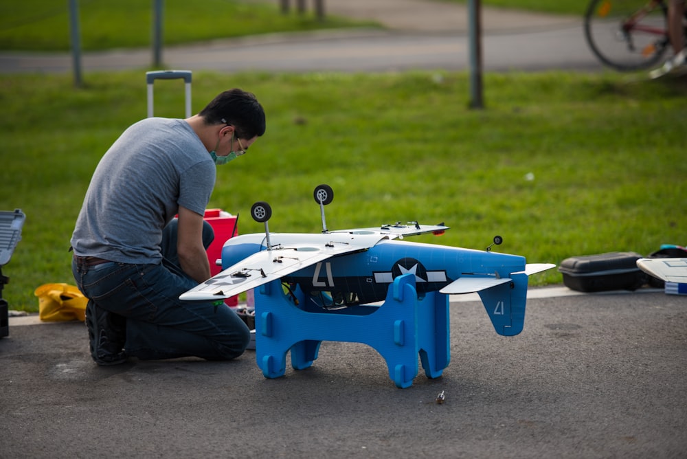 a man working on a small blue and white plane